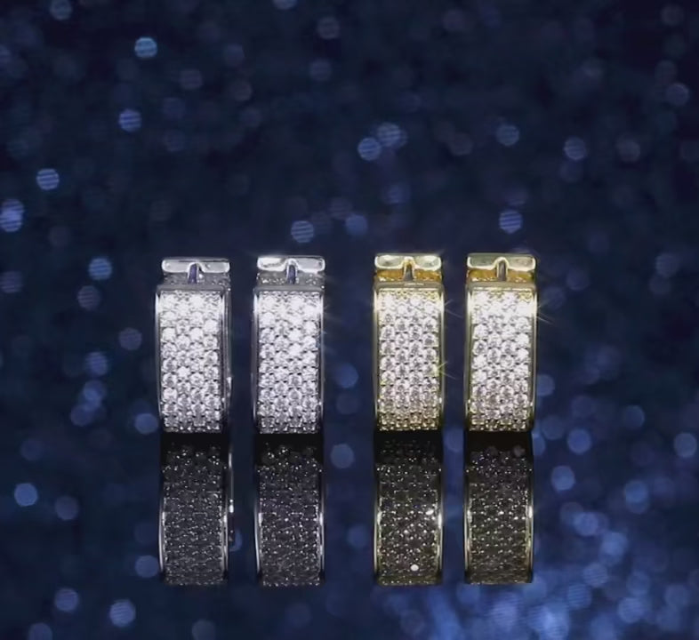 Close-up video of The Quadra Radiant Hoops — Geometric Artisan Edition, showcasing their polished silver-finish and unique architectural square structure as they rotate elegantly, reflecting light with structural grace.