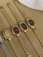 Top view of ZÜRVRA Oval Heritage watches in gold and silver finishes, featuring Roman numeral dials in burgundy, green, black, and champagne.