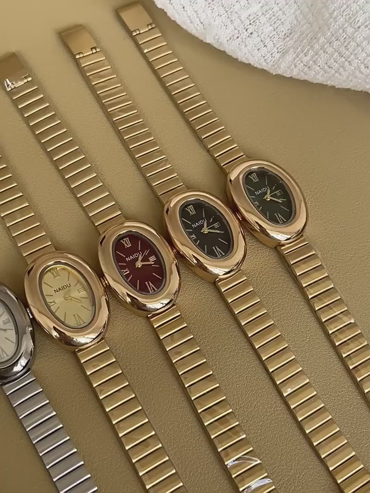 Top view of ZÜRVRA Oval Heritage watches in gold and silver finishes, featuring Roman numeral dials in burgundy, green, black, and champagne.