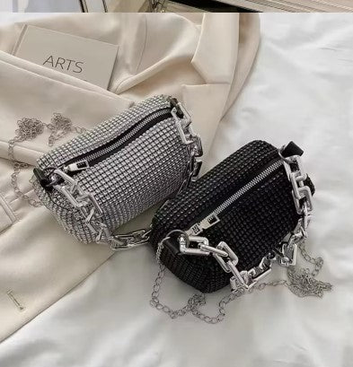 The Radiant Cylinder — Artisan Strass Edition in Midnight Black featuring a silver geometric chain. The video showcases the light-reflecting crystals and architectural silhouette against a classic neutral ensemble.