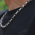 Detailed view of the ZÜRVRA Linear Link industrial chain in silver stainless steel, highlighting the alternating textured rectangular links and robust clasp.